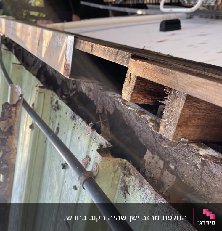 גג מתכת עם נזקי חלודה ועץ חשוף